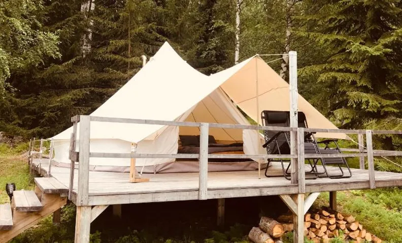 Glamping tent in a forest, lake view